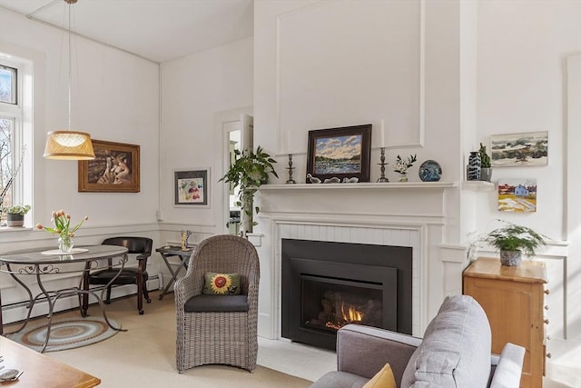 living area featuring a glass covered fireplace and baseboard heating