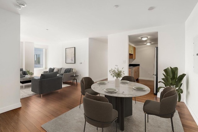 dining area featuring dark wood-type flooring and baseboards