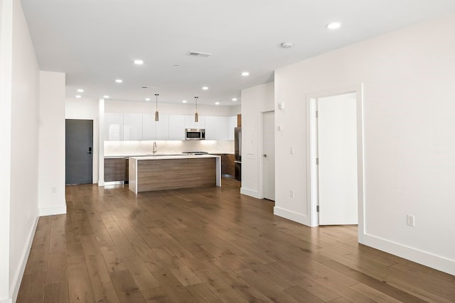 kitchen featuring dark hardwood / wood-style flooring, white cabinetry, a center island, and appliances with stainless steel finishes