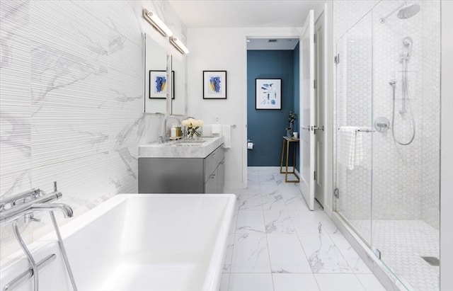 bathroom with tile walls, vanity, plus walk in shower, and tile patterned flooring