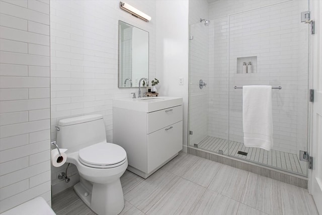 bathroom featuring toilet, tile walls, an enclosed shower, tile patterned flooring, and vanity