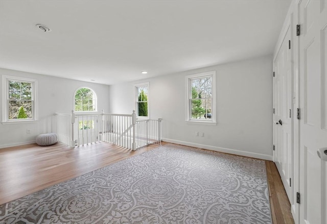 empty room with baseboards, recessed lighting, and wood finished floors