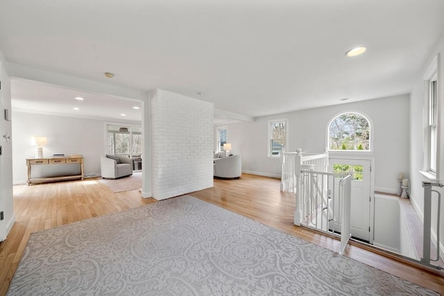 interior space with wood finished floors, a wealth of natural light, and an upstairs landing