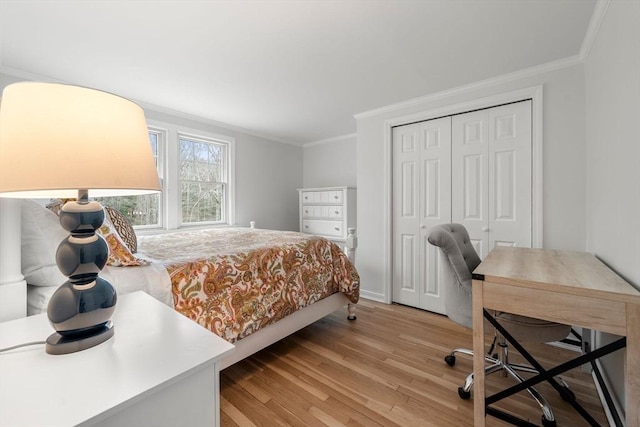 bedroom featuring crown molding, light wood-style floors, and a closet