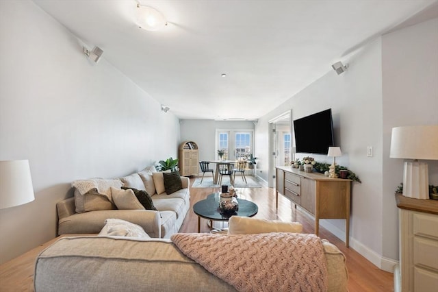 living room with baseboards and light wood-style flooring