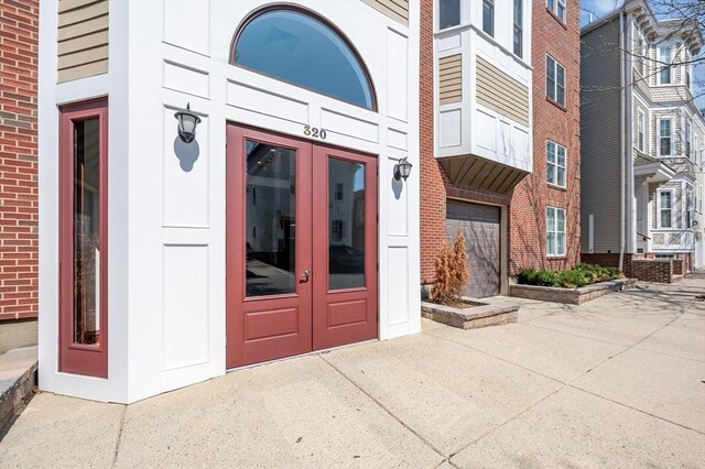 property entrance featuring french doors and brick siding