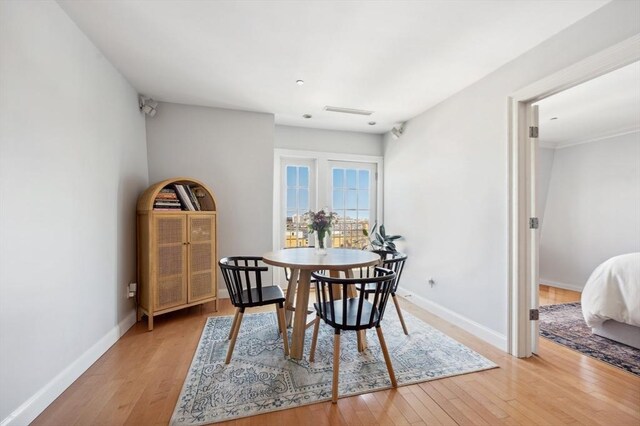 dining area with baseboards, visible vents, and light wood-style floors