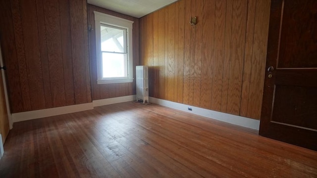 31 Burton St, Springfield, MA 01108 - unfurnished room featuring radiator, wood finished floors, wood walls, and baseboards
