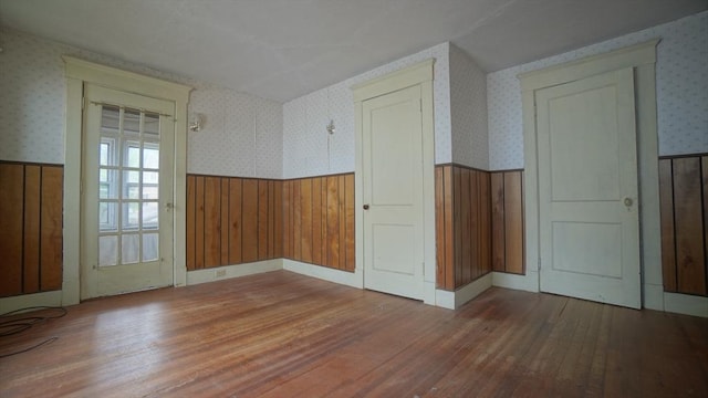 31 Burton St, Springfield, MA 01108 - empty room with wainscoting, hardwood / wood-style flooring, wallpapered walls, and wooden walls