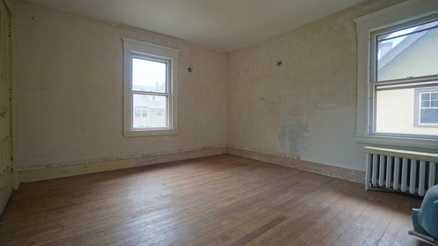 31 Burton St, Springfield, MA 01108 - spare room featuring radiator heating unit, hardwood / wood-style flooring, and healthy amount of natural light