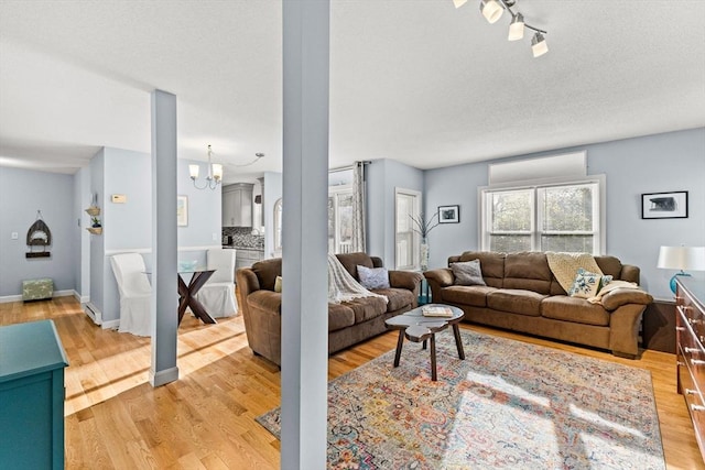 living area with light wood finished floors and an inviting chandelier