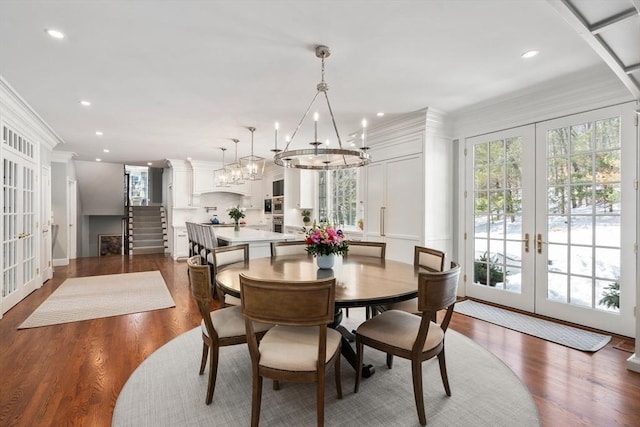 dining area with dark wood-style floors, french doors, crown molding, recessed lighting, and a chandelier