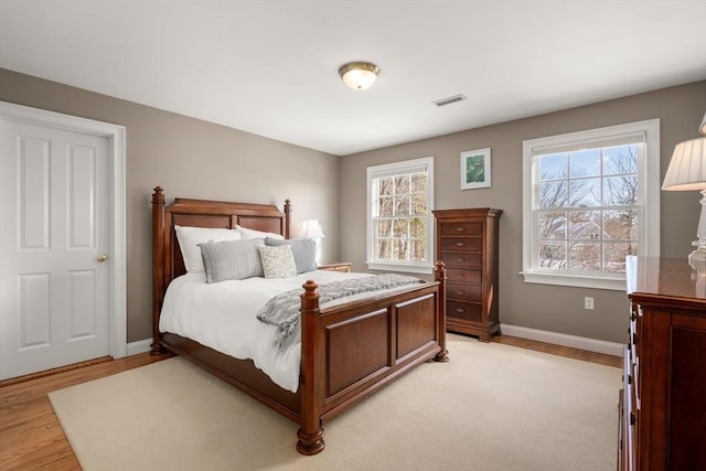 bedroom with baseboards, multiple windows, and visible vents