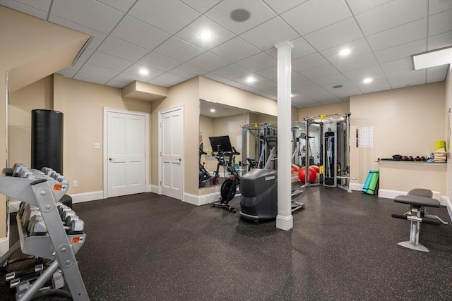 exercise room featuring a paneled ceiling, baseboards, and recessed lighting