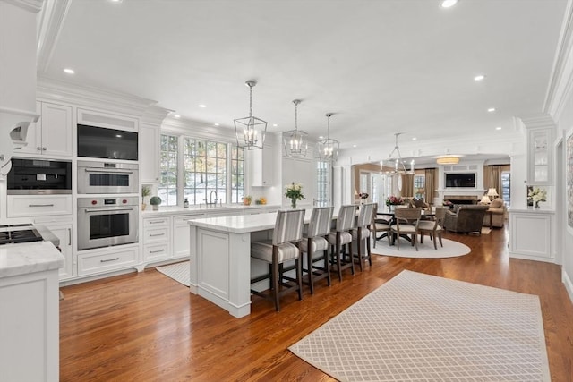 kitchen featuring a kitchen bar, white cabinetry, open floor plan, and a center island