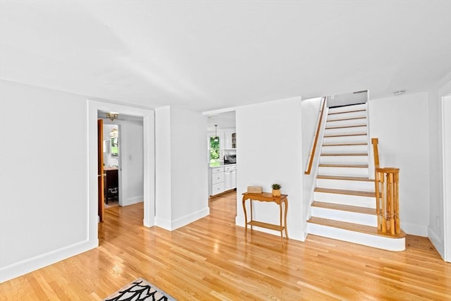 67 Greenfield Ln, Scituate, MA 02066 - spare room with light wood-type flooring, stairway, and baseboards