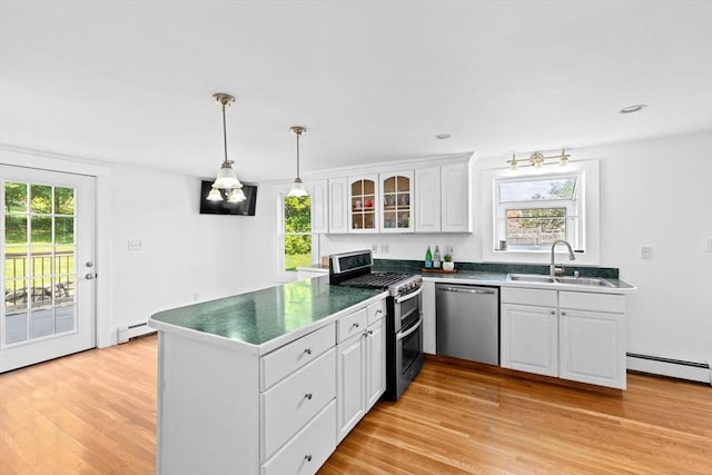 67 Greenfield Ln, Scituate, MA 02066 - kitchen with stainless steel appliances, a sink, a peninsula, white cabinetry, and light wood-type flooring