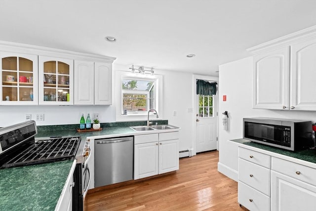 67 Greenfield Ln, Scituate, MA 02066 - kitchen with stainless steel appliances, a sink, white cabinetry, dark countertops, and light wood-style flooring