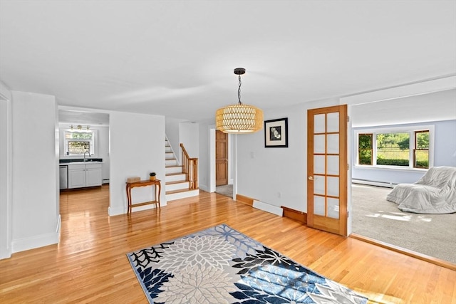 67 Greenfield Ln, Scituate, MA 02066 - living room with stairs, french doors, light wood-style flooring, a baseboard heating unit, and baseboards