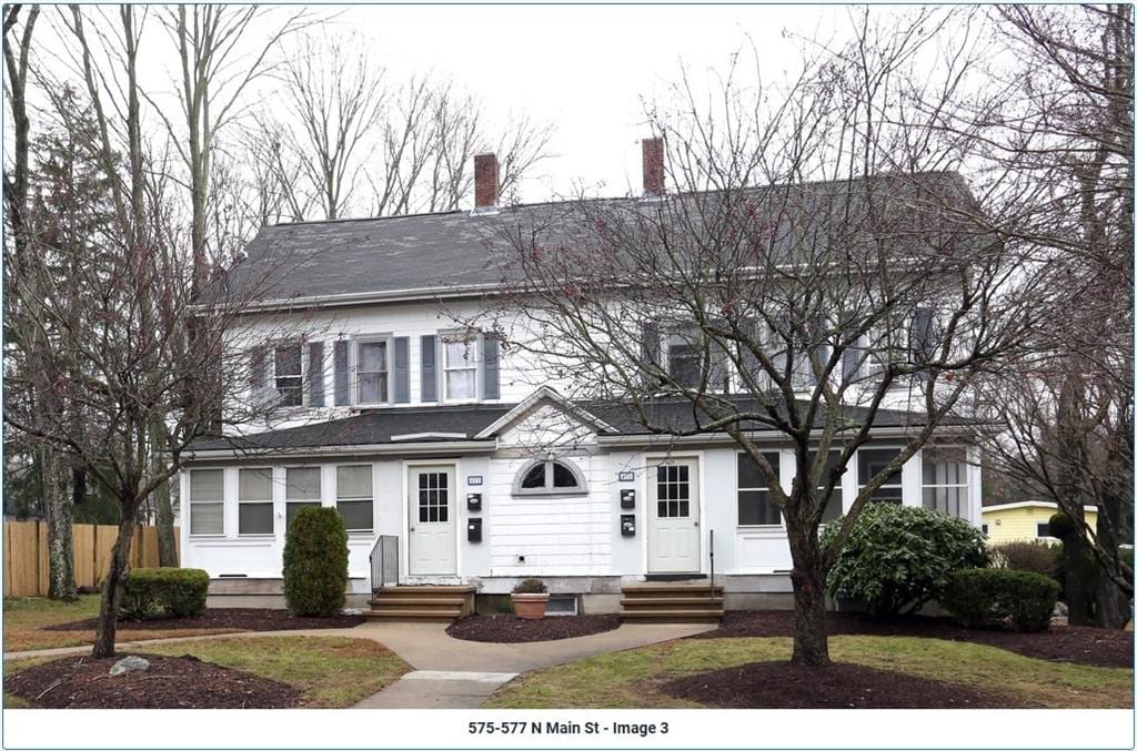 view of front of property featuring entry steps, a chimney, and fence