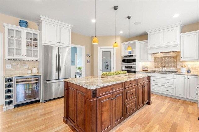 kitchen with wine cooler, white cabinetry, stainless steel appliances, and a center island