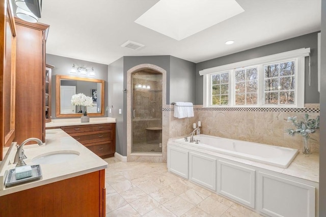 full bathroom with two vanities, visible vents, a sink, a shower stall, and a bath