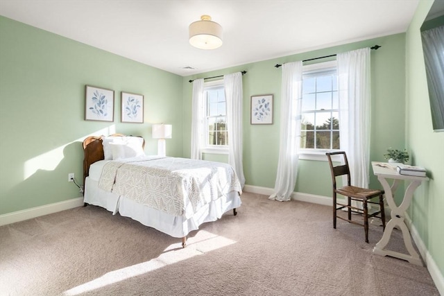 carpeted bedroom featuring multiple windows, visible vents, and baseboards