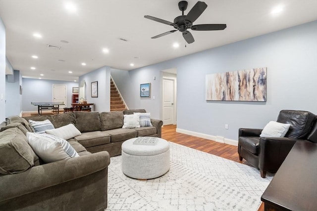 living area with recessed lighting, visible vents, wood finished floors, baseboards, and stairs