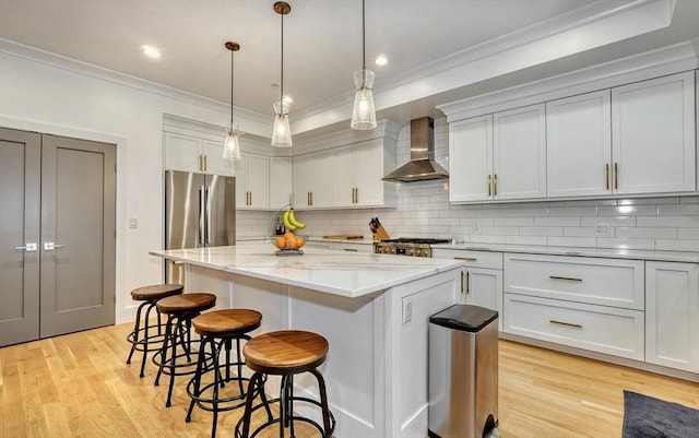 11 Conway St Unit 3, Boston, MA 02131 - kitchen with wall chimney exhaust hood, crown molding, stainless steel fridge, a kitchen bar, and a center island