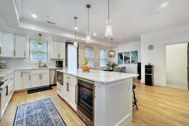 11 Conway St Unit 3, Boston, MA 02131 - kitchen featuring beverage cooler, crown molding, tasteful backsplash, light wood-style floors, and white cabinetry