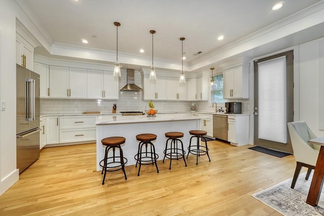 11 Conway St Unit 3, Boston, MA 02131 - kitchen featuring appliances with stainless steel finishes, wall chimney exhaust hood, light wood-style floors, tasteful backsplash, and a breakfast bar