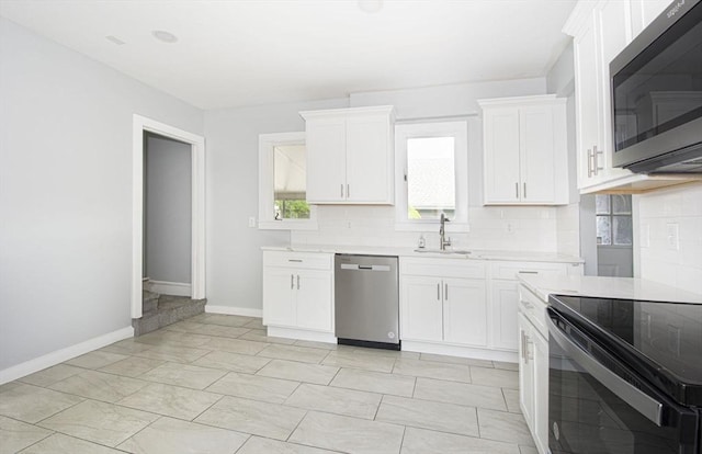 kitchen featuring backsplash, sink, white cabinetry, and stainless steel appliances