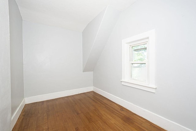 additional living space with hardwood / wood-style floors and lofted ceiling