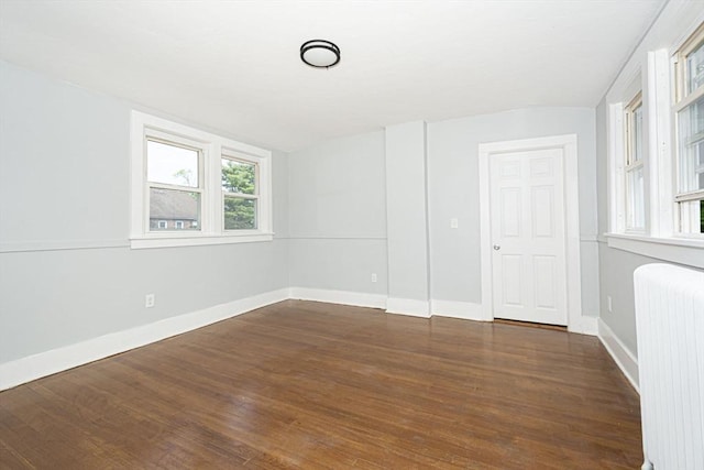 spare room featuring radiator and dark hardwood / wood-style flooring