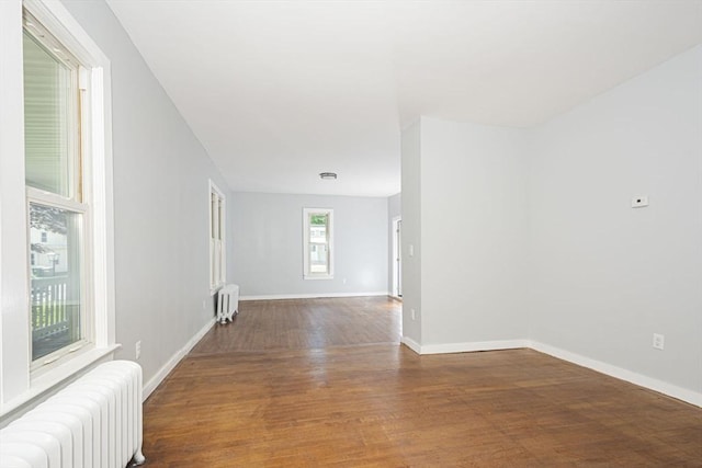 empty room featuring dark hardwood / wood-style floors and radiator