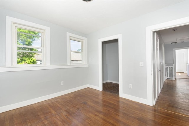 unfurnished bedroom featuring dark hardwood / wood-style floors and a spacious closet