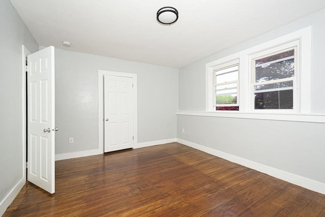 unfurnished room with dark hardwood / wood-style flooring