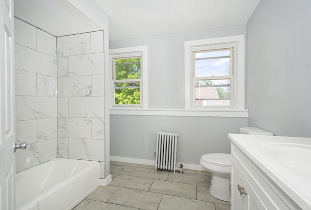 full bathroom featuring vanity, tiled shower / bath combo, toilet, and radiator