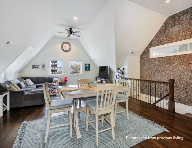 dining area with lofted ceiling with skylight, ceiling fan, and dark wood-type flooring