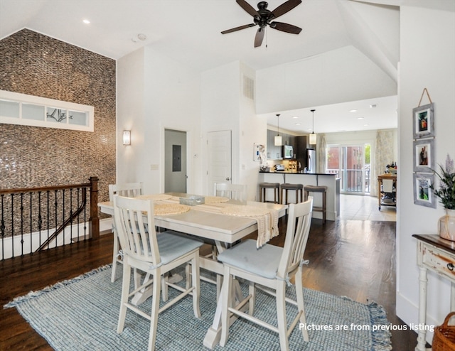 dining space with dark hardwood / wood-style flooring, high vaulted ceiling, and ceiling fan