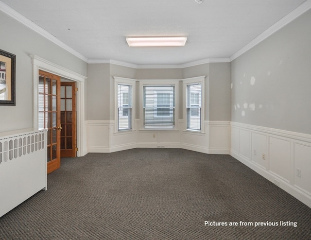 empty room with dark colored carpet and ornamental molding