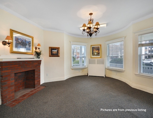 unfurnished living room featuring dark colored carpet, an inviting chandelier, a brick fireplace, and crown molding