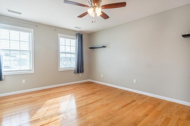 spare room featuring ceiling fan, a healthy amount of sunlight, and light wood-type flooring