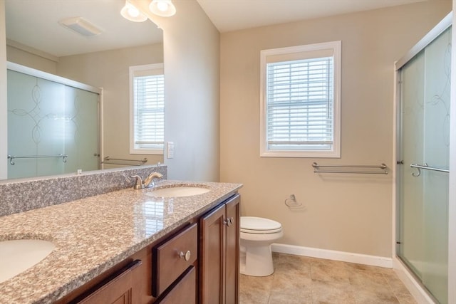 bathroom featuring vanity, a healthy amount of sunlight, and a shower with shower door