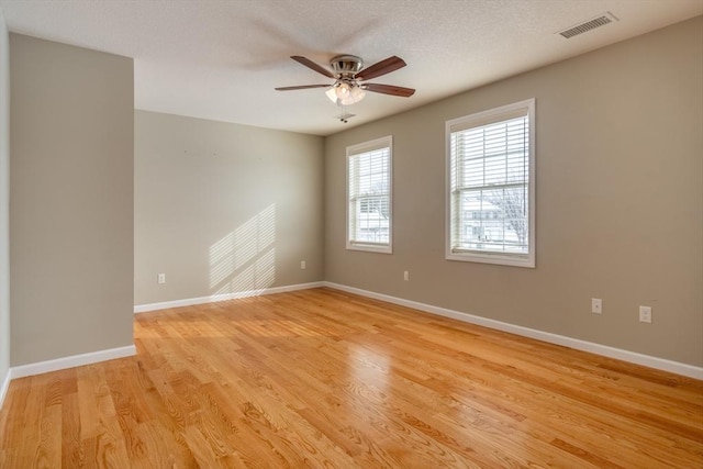 unfurnished room with ceiling fan, light hardwood / wood-style flooring, and a textured ceiling