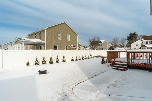 snow covered back of property with a wooden deck