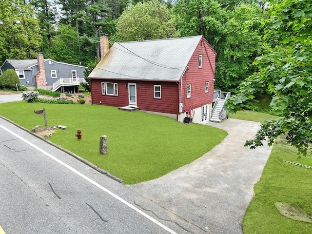 77 Marblehead St, North Reading, MA 01864 - chalet / cabin featuring asphalt driveway, stairway, a front yard, a chimney, and view of scattered trees