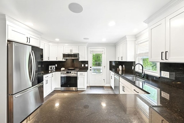 77 Marblehead St, North Reading, MA 01864 - kitchen with stainless steel appliances, a sink, white cabinetry, decorative backsplash, and crown molding