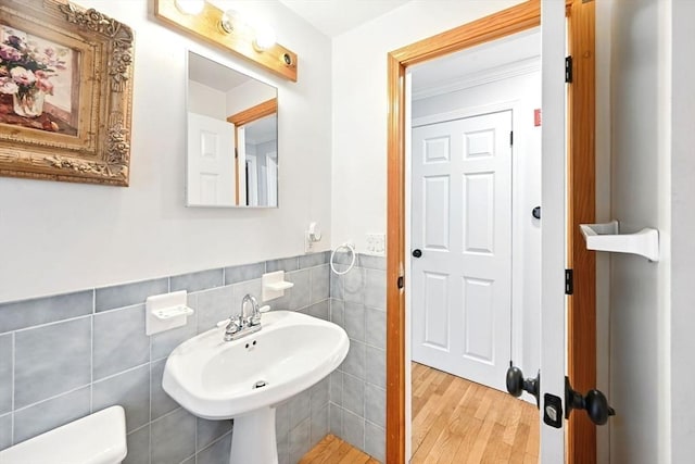 77 Marblehead St, North Reading, MA 01864 - bathroom with tile walls, a wainscoted wall, wood finished floors, a sink, and crown molding