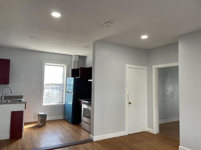 629 Cambridge St, Worcester, MA 01610 - kitchen with stainless steel electric stove, a sink, wood finished floors, baseboards, and recessed lighting